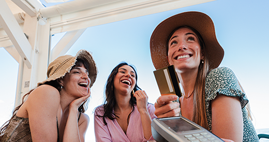 Un groupe de jeunes femmes qui règlent l'addition avec une carte de crédit