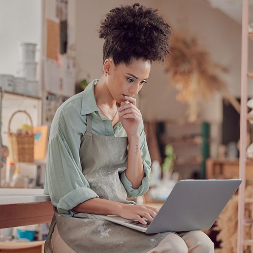 femme qui reflechie devant un ordinateur portable
